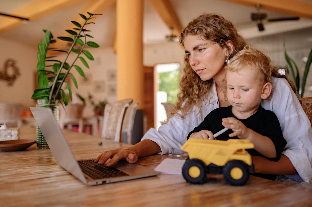 Mother balancing work at home while spending time with her child.