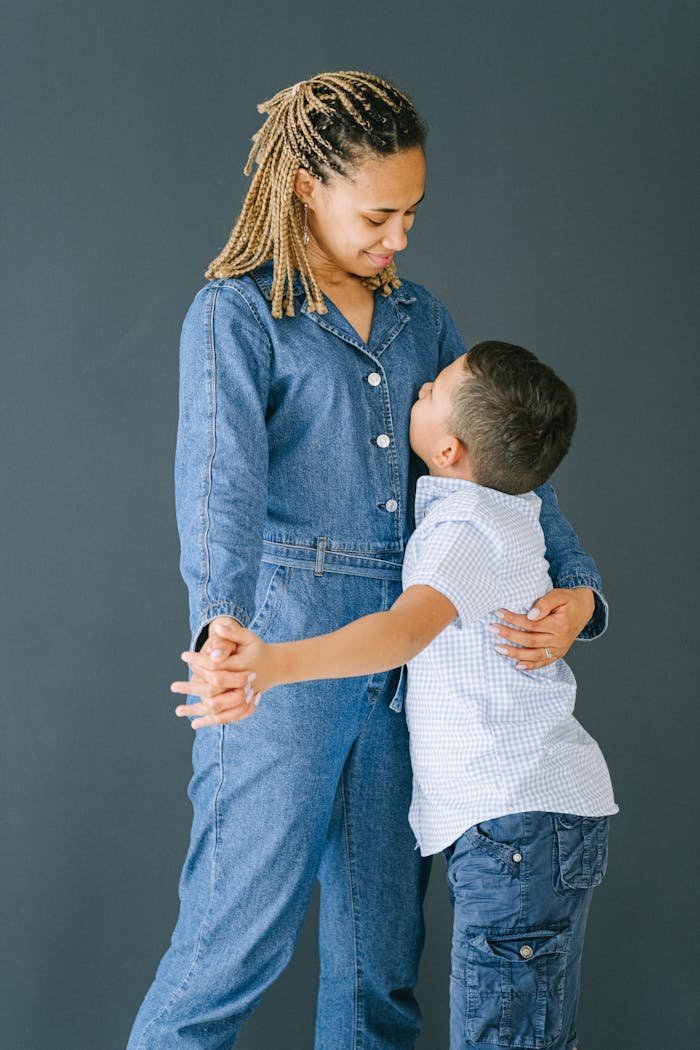 gallery-03 A heartwarming scene of a mother and son sharing a joyful hug indoors.