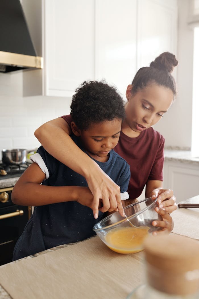 gallery-05 A mother and her young son bonding while preparing food in the kitchen.